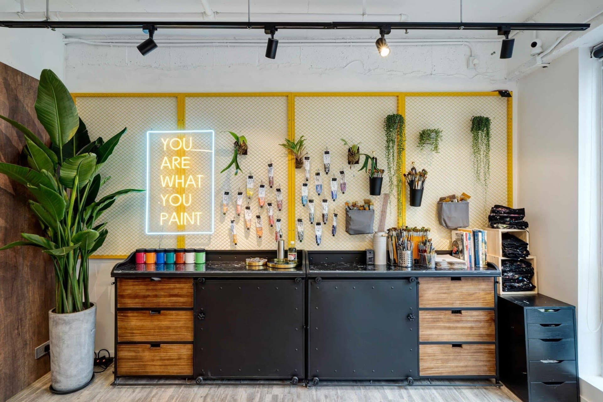 Studio 83 Hong Kong neon YOU ARE WHAT YOU PAINT wall with paint tubes and brushes in the Central art studio